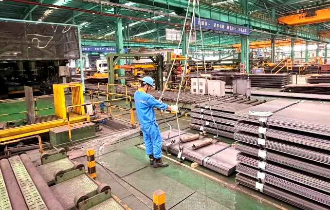 Worker handling steel plates with lifting equipment in the warehouse Worker handling steel plates with lifting equipment in the warehouse